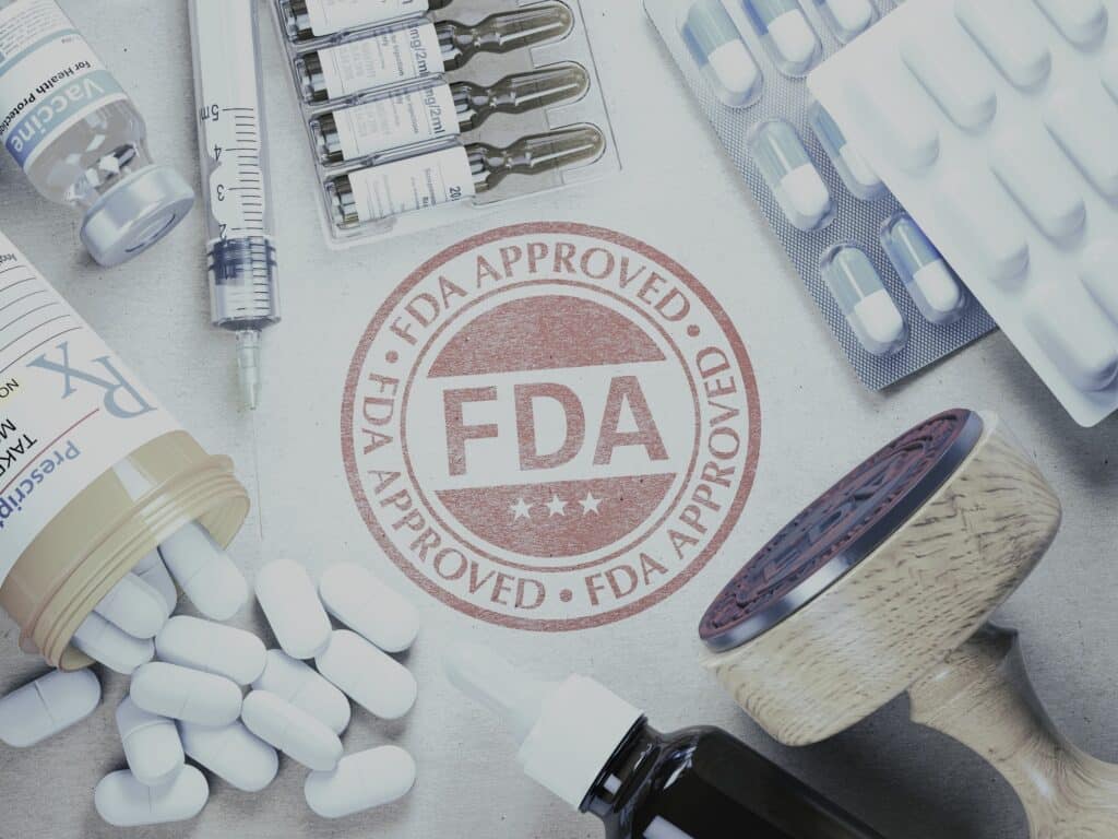 A stamp "fda approved " and pills on a table