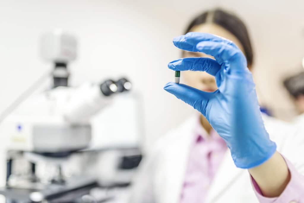 Female lab technician showing a capsule in a laboratory