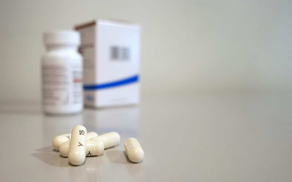 Capsules lying on a table besides the container