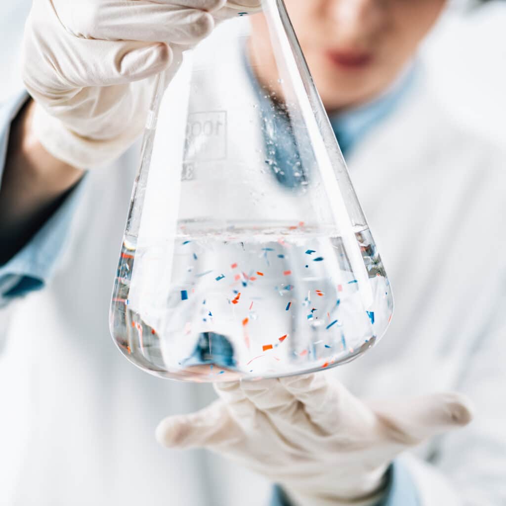 A lab technician examining particles in a liquid.